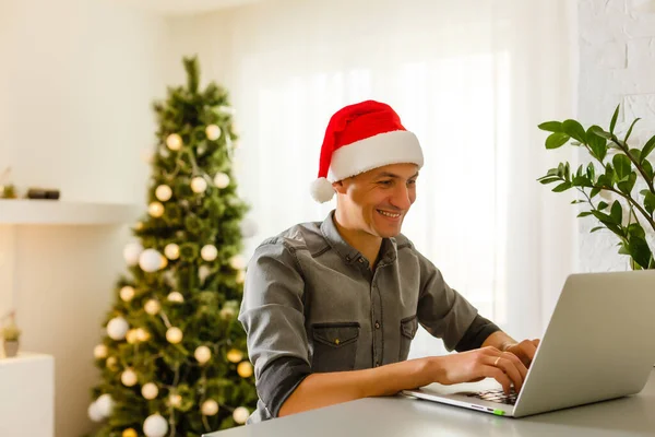 Людина Капелюсі Санта Клауса Тримає Ноутбук Веселим Різдвяним Набором — стокове фото