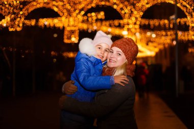 Noel 'de eski kasabanın sokaklarında sihir. Noel 'de mutlu genç bir anne ve kız