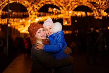 Noel 'de eski kasabanın sokaklarında sihir. Noel 'de mutlu genç bir anne ve kız
