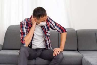 Üzgün adam elleriyle yüzüne dokunur. Çaresiz durumda. Solunum yolu enfeksiyonunu COVID-19 'dan korumak için tıbbi maske takıyor. Pandemik koronavirüse karşı önlem. Beyaz arkaplan.