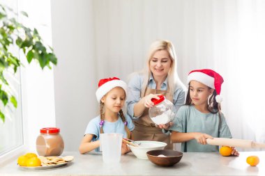 Mutlu anne ve çocuklar Noel kurabiyesi pişirir.