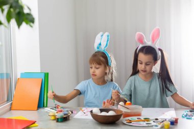 Mutlu Paskalyalar. Paskalya yumurtalarını boyayan iki kardeş. Mutlu aile çocukları Paskalya için hazırlanıyor. Paskalya günü tavşan kulağı takan şirin bir kız çocuğu..
