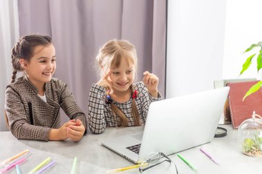 İnternette okuyan iki küçük kız. Çevrimiçi Uzaklık Öğrenme, e-öğrenme, konsept