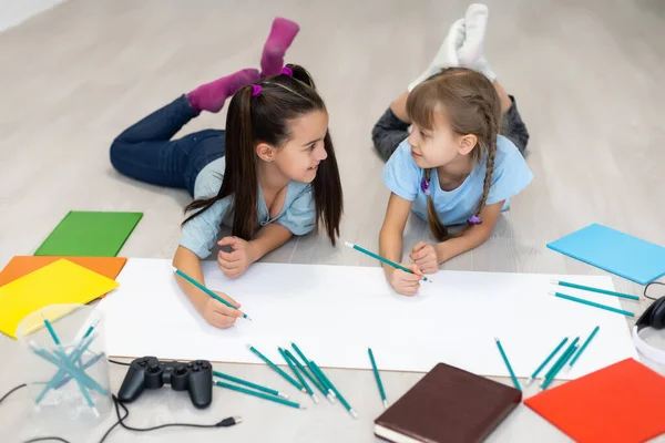 Küçük Kız Kardeş Evin Zeminine Uzanır Renkli Kalemlerle Kağıt Üzerine — Stok fotoğraf