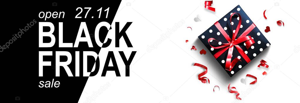 gift box with red ribbon and a black signboard with the text black friday written in white