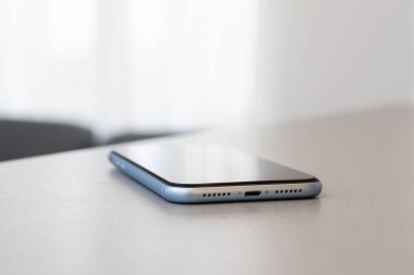 Gri masada tek bir cep telefonu.