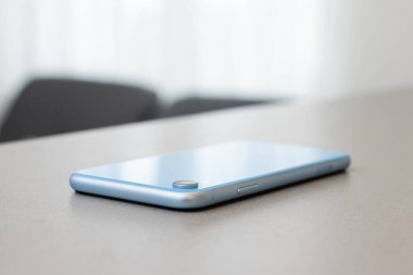 Siyah taş masa zemininde boş ekranlı modern cep telefonu. Eski koyu gri kumaş arka planında akıllı telefon.