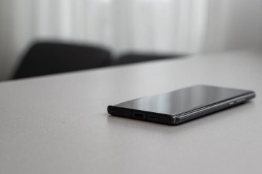 Gri masada tek bir cep telefonu.