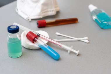 Şırıngalar, gri arka planda ilaç şişeleri..