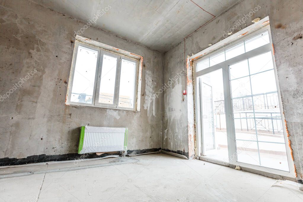 Empty room before repair. Gray walls unfinished