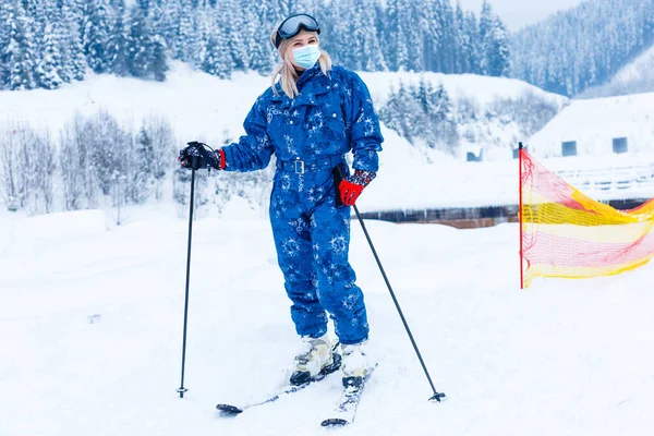 一名戴着医疗面罩的女滑雪者在滑雪场雪山上的画像 — 图库照片