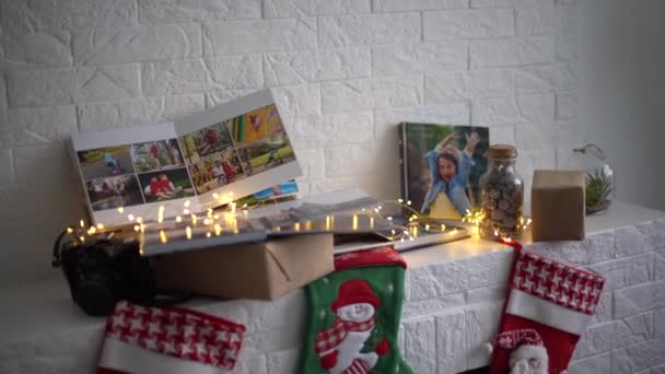 Geschenke Fotobuch Und Weihnachtssocken Kamin Lichterkranz — Stockvideo