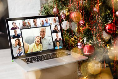 Bilgisayarında video kaydı ve arka planda ışıklar olan Noel ağacı var.