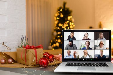 Bilgisayarında video kaydı ve arka planda ışıklar olan Noel ağacı var.