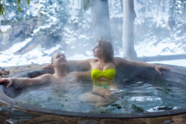 people in hot baths with thermal waters in the mountains in winter clipart