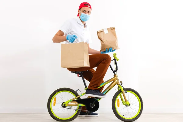 一个戴防护面罩的男人正在骑自行车运送食物 网上购物和快递服务 — 图库照片