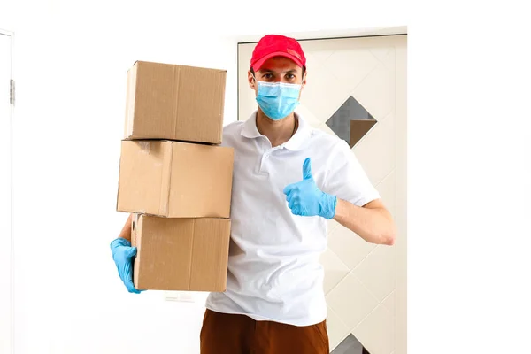 Мужчина Медицинской Маске Синих Резиновых Перчатках Коробкой Посылкой Руках Доставка — стоковое фото