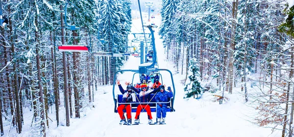 Ski lift - happy skiers in ski resort