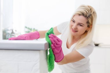 Güzel kız yüzeyi temizler.