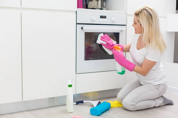 Γυναίκα Στην Κουζίνα Χαμογελάει Και Σκουπίζει Σκόνη Χρησιμοποιώντας Ένα Σπρέι — Φωτογραφία Αρχείου