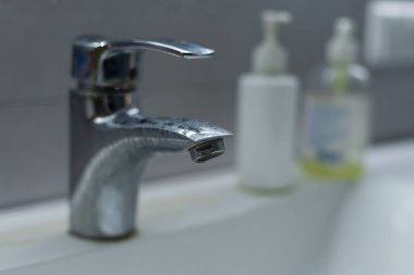 Pas lekeleri, kireç boyası ve banyoda musluğu olan eski kirli lavabo, su musluğu..