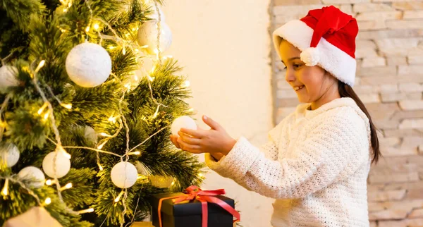 Süveter Giyen Küçük Bir Kız Noel Ağacına Işık Takı Takıyor — Stok fotoğraf