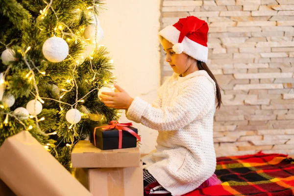 Klein Meisje Trui Opknoping Ornamenten Aan Kerstboom Met Licht Bauble — Stockfoto