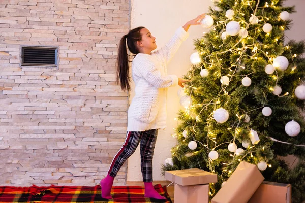 Klein Meisje Trui Opknoping Ornamenten Aan Kerstboom Met Licht Bauble — Stockfoto