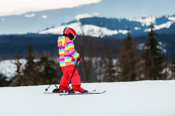 スキー場で雪に覆われた山の上のCovid 19コロナウイルス中の医療用マスクの少女スキーヤーの肖像 — ストック写真