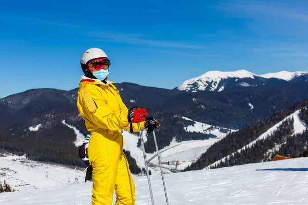 在一个阳光明媚的冬日 在一个滑雪胜地 一名戴着医疗面罩的妇女在驾驶Covid 19号护卫舰 — 图库照片