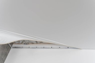 Tamirciler PVC vinil filmden yapılmış esnek tavanı gaz tabancasıyla kuruyorlar.