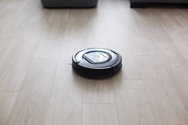 Yerde robotik süpürge var.