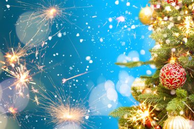 Arka planda Noel ışığı saçan bir maytap.