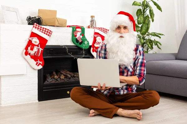 Άγιος Βασίλης Κάθεται Ένα Φορητό Υπολογιστή Στο Παρασκήνιο Του Τζακιού — Φωτογραφία Αρχείου