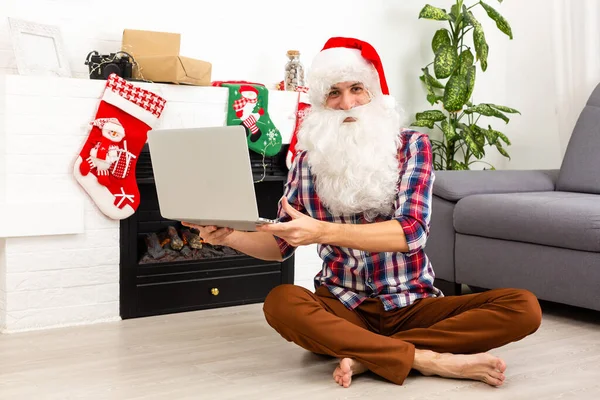 Papá Noel Con Portátil Sentado Mesa Habitación Decorada Para Navidad —  Fotos de Stock
