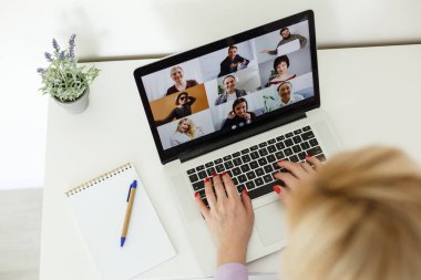 Kadın çalışanın, çeşitli çok ırklı meslektaşlarıyla çevrimiçi brifingde yaptığı video konuşmasında arka planda, kadın çalışanın modern laptopta iş arkadaşlarıyla Webcam grup konferansı var.