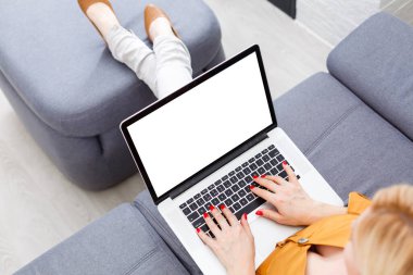 Bilgisayarın önünde oturan ve bilgileriniz veya içeriğiniz için boş ekranı olan bir kadın akıllı telefonla konuşurken iş kadını, modern kahve dükkanında kahvaltıda defter üzerinde çalışır.