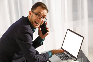 Önünde boş ekranı olan ve sizin bilgileriniz veya içeriğiniz için boş ekranı olan bir erkeğin arka planı. Not defteriyle çalışan modern bir iş adamı.