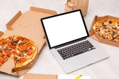 Mutfakta boş beyaz ekranlı dizüstü bilgisayar. İnternette aşçılık kursları ya da yemek tarifleri. Ev yemeği konsepti. Yemek günlüğü
