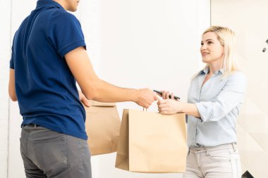 Karton kutular taşıyan teslimatçı. Hızlı ve ücretsiz teslimat. İnternetten alışveriş ve ekspres teslimat. Karantina