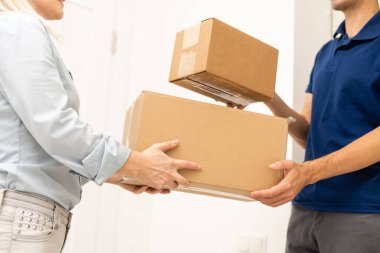 Karton kutular taşıyan teslimatçı. Hızlı ve ücretsiz teslimat. İnternetten alışveriş ve ekspres teslimat. Karantina