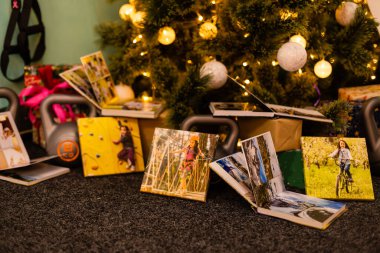 Noel ağacının yanındaki spor için hediye olarak fotobook, albüm ve ağırlıklar