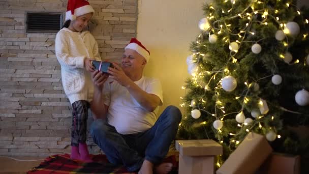 Grandpa Wearing Santa Hat Makes Christmas Present His Little Granddaughter — Stock Video