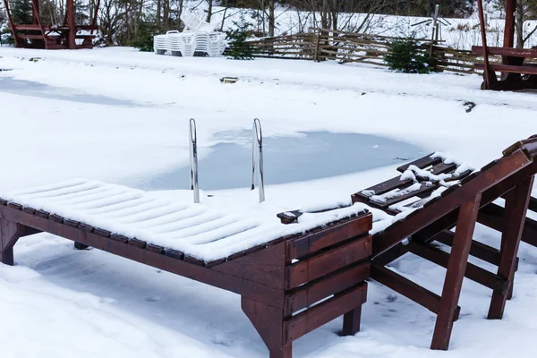 Open air swimming pool in the winter snowfall