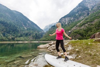 Kaygısız kadın turist gölün yakınındaki ormanda dinleniyor.