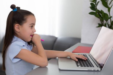 Bilgisayarla çalışan küçük kız çevrimiçi öğrenim