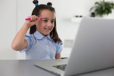 Evdeki çevrimiçi dersi sırasında ev ödevi matematik okuyan oldukça şık bir öğrenci karantina sırasındaki sosyal mesafeler, kişisel izolasyon, çevrimiçi eğitim konsepti, evde eğitim veren biri.