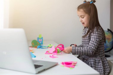 Sanat dersinde kağıt kesen güzel küçük bir kız. Çocuk eğitimi konsepti. Çocuk işi. Okula geri dön.