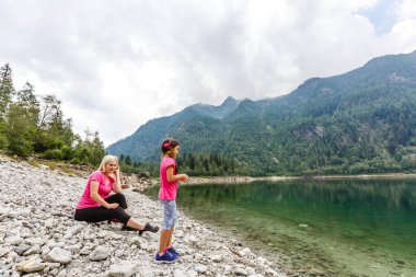 Anne ve kızı İtalya Gölü yakınlarındaki dağlarda yürüyorlar.