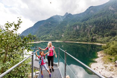 Anne ve kızı İtalya Gölü yakınlarındaki dağlarda yürüyorlar.